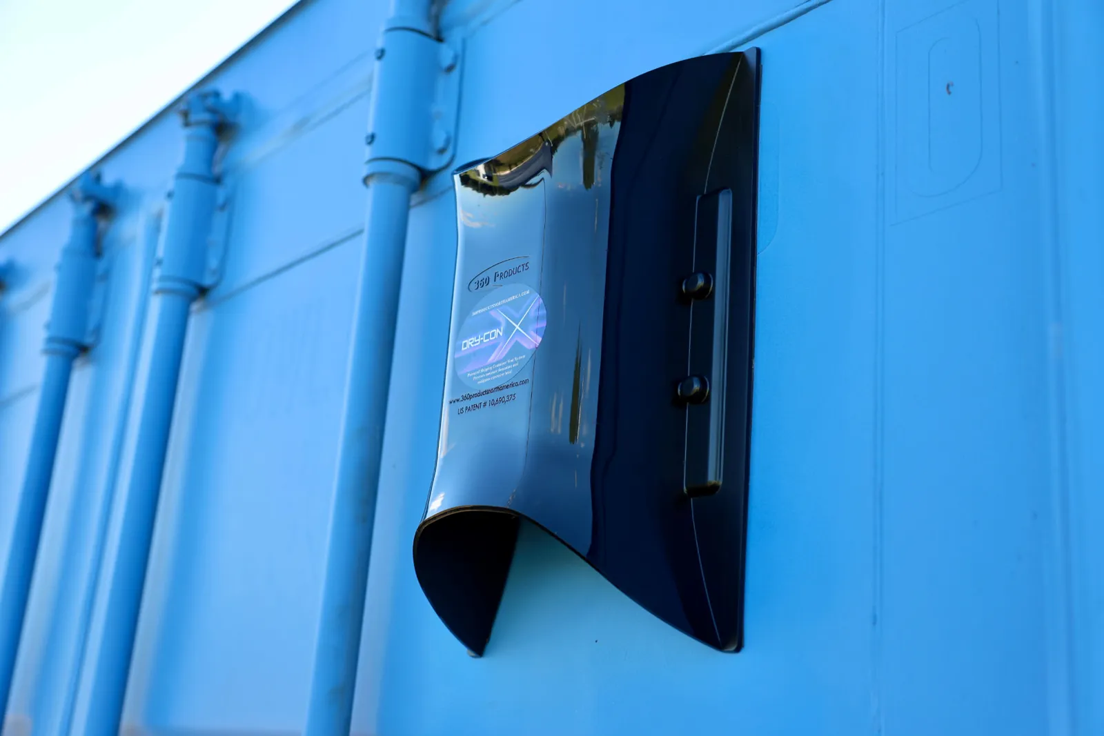 Installed black DRY-CON X exhaust vent on a blue shipping container